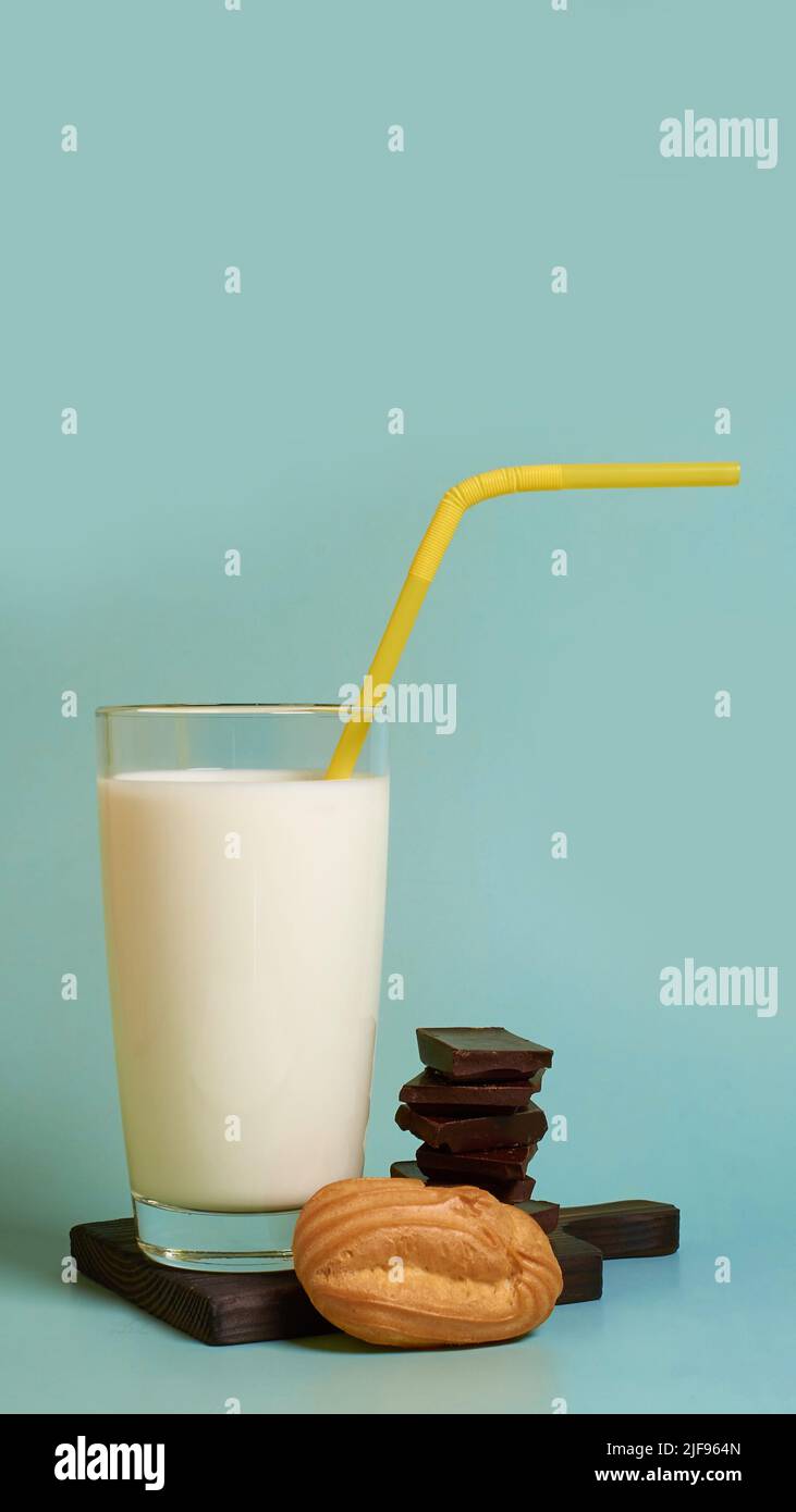 A glass of milk, cake and pieces of dark chocolate on a wooden stand  Stock Photo