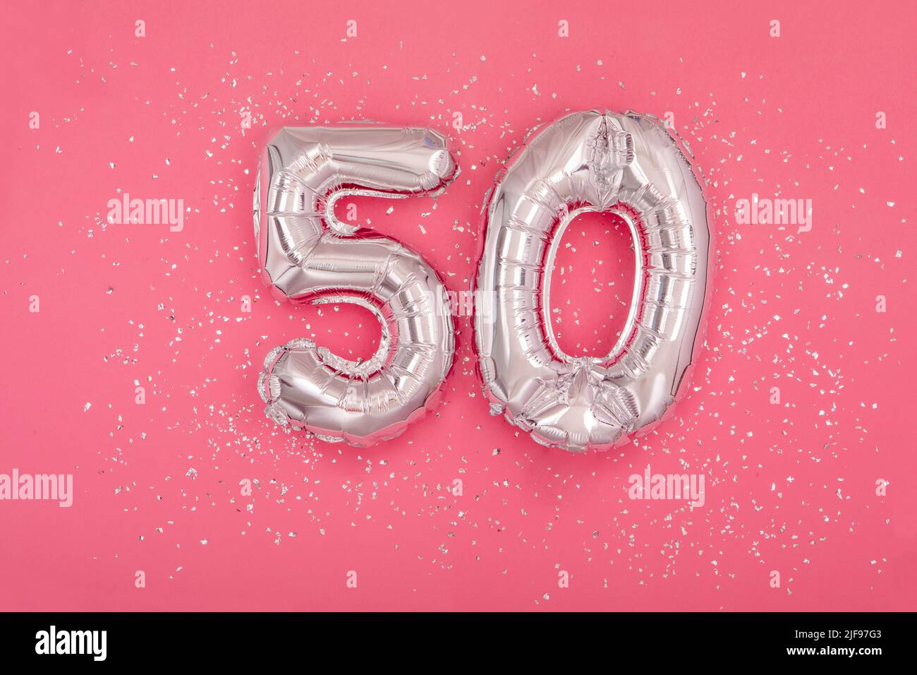 Silver balloon in shape of number fifty 50 pink background Stock Photo