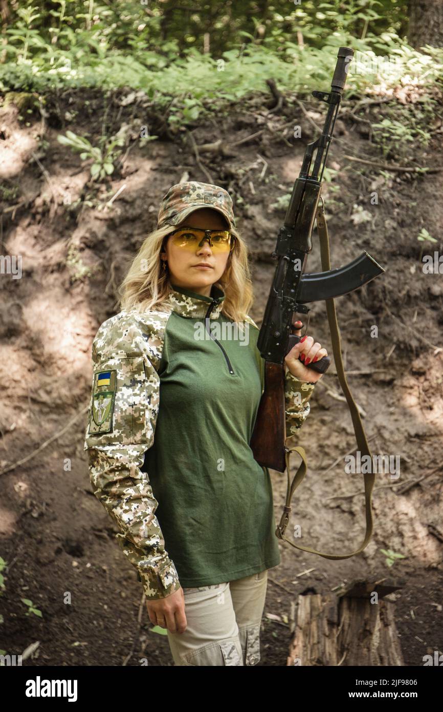 Portrait of a Ukrainian military woman with a machine gun in the hands ...