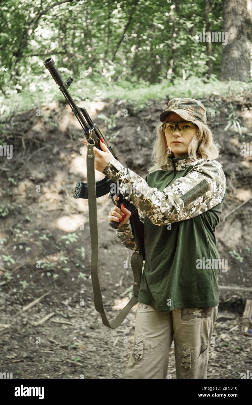 Portrait of a Ukrainian military woman with a machine gun in the hands ...