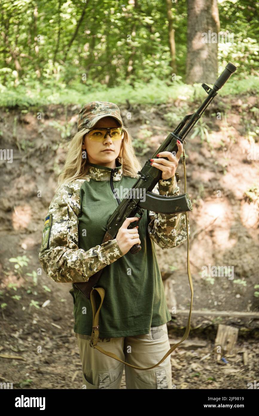 Portrait of a Ukrainian military woman with a machine gun in the hands ...