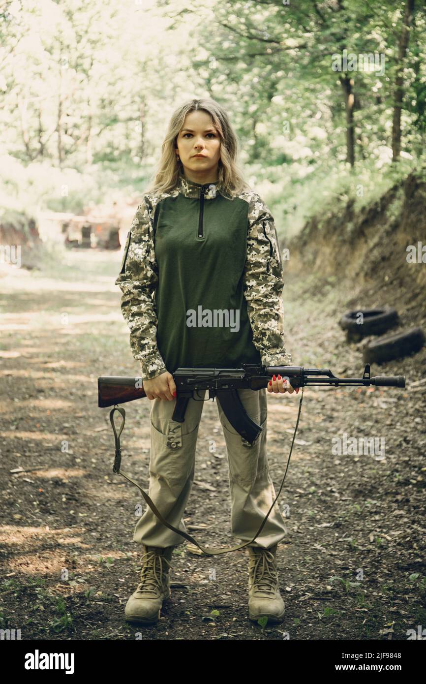 Portrait of a Ukrainian military woman with a machine gun in the hands ...