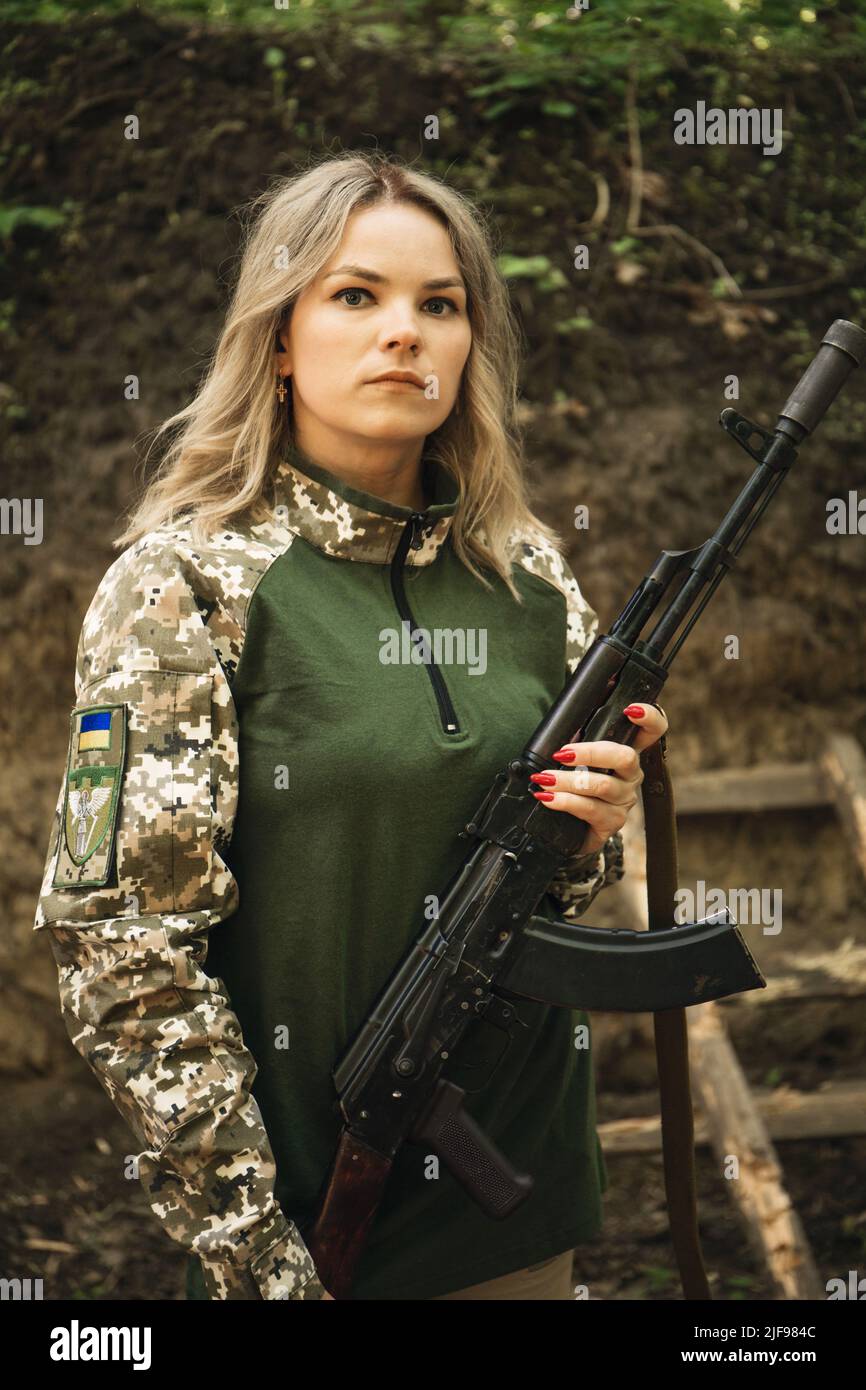 Portrait of a Ukrainian military woman with a machine gun in the hands ...