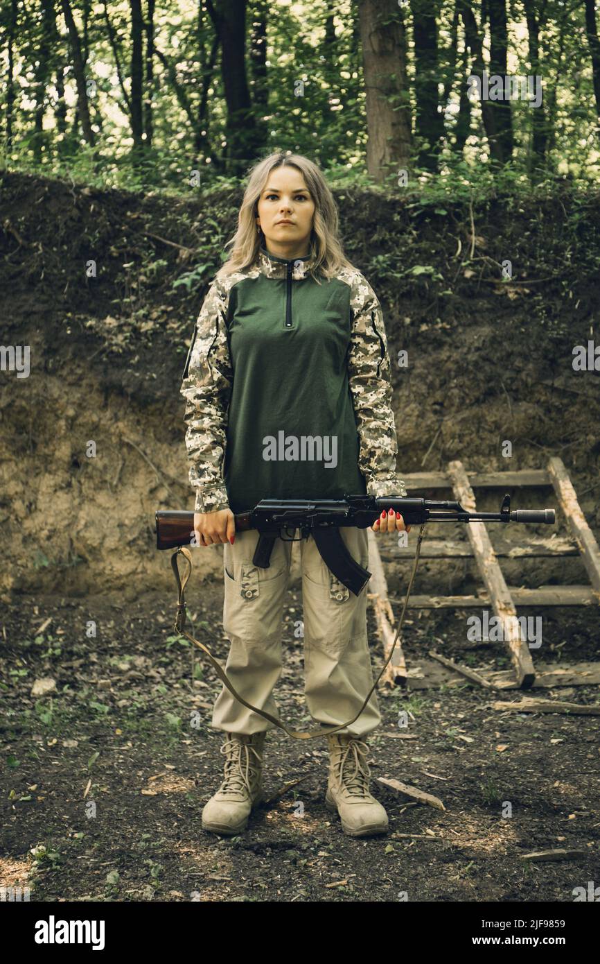Portrait of a Ukrainian military woman with a machine gun in the hands ...