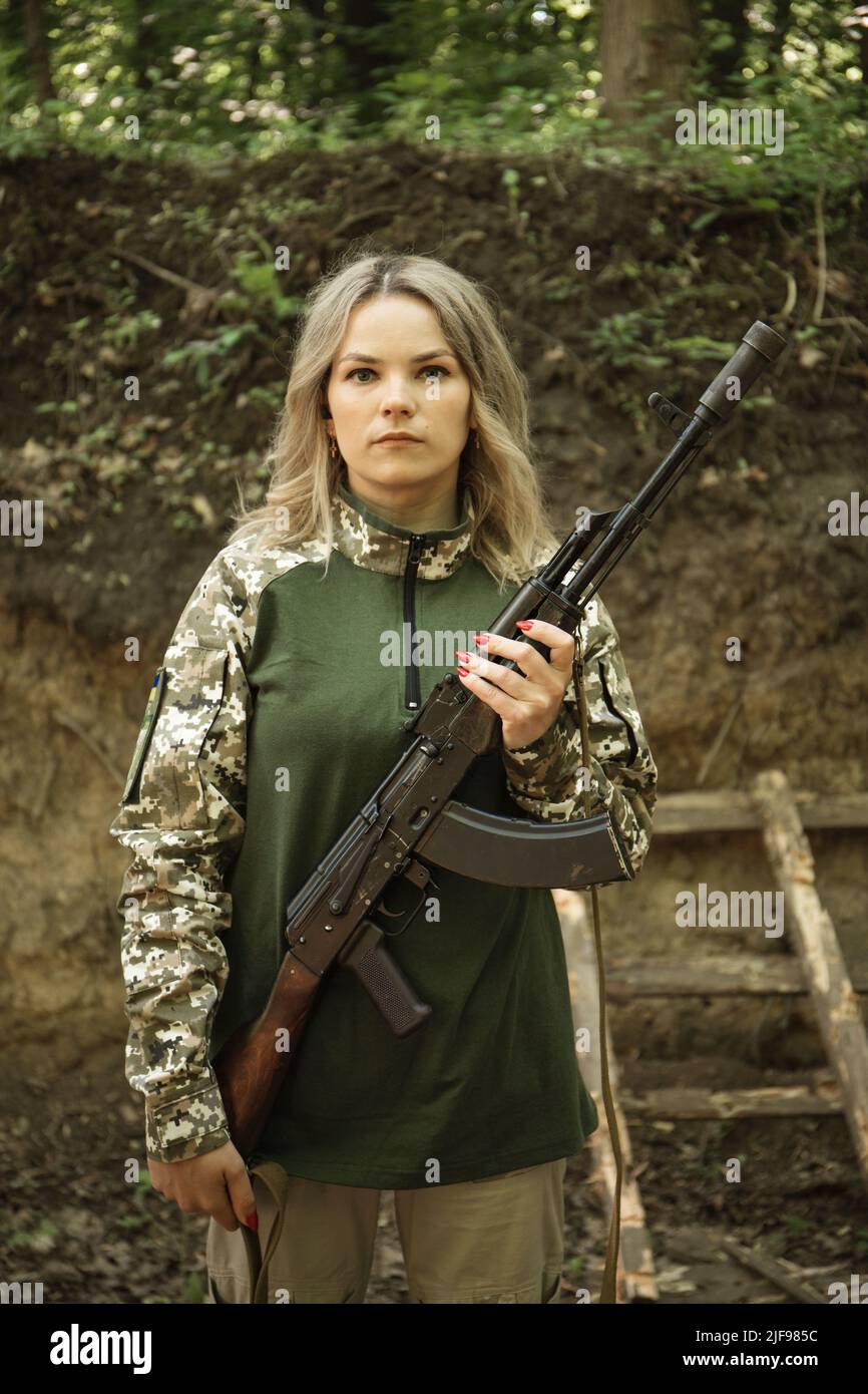 Portrait of a Ukrainian military woman with a machine gun in the hands ...