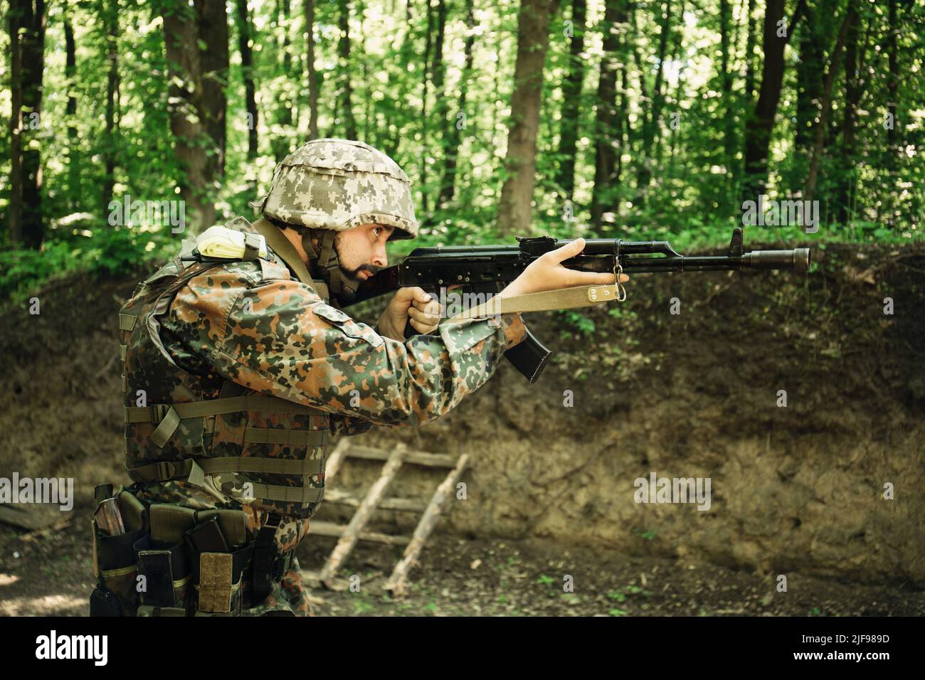 Portrait of a Ukrainian military man with a Kalashnikov assault rifle ...