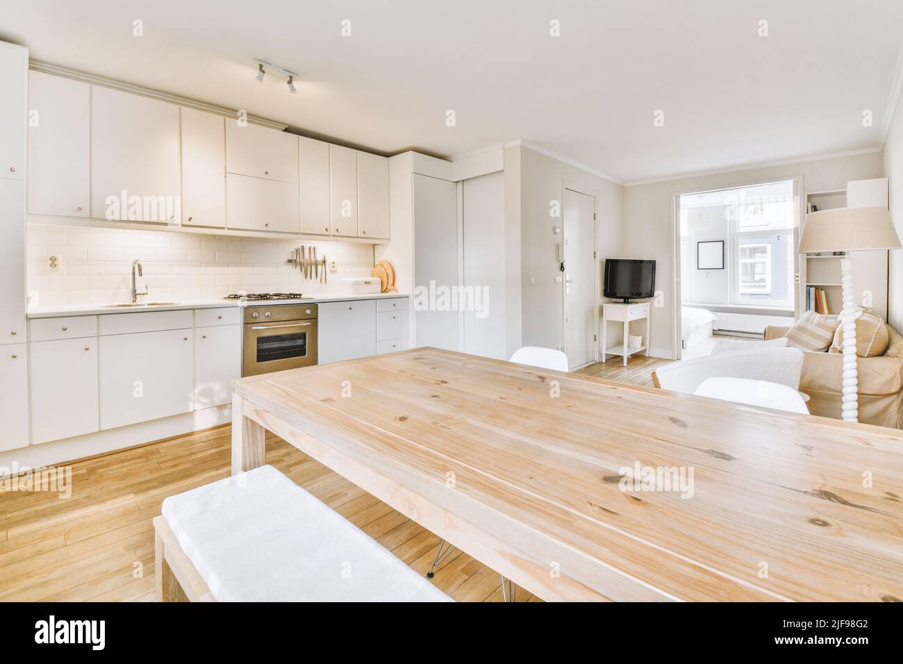 Contemporary open plan kitchen with dining table set and gray sofa in ...