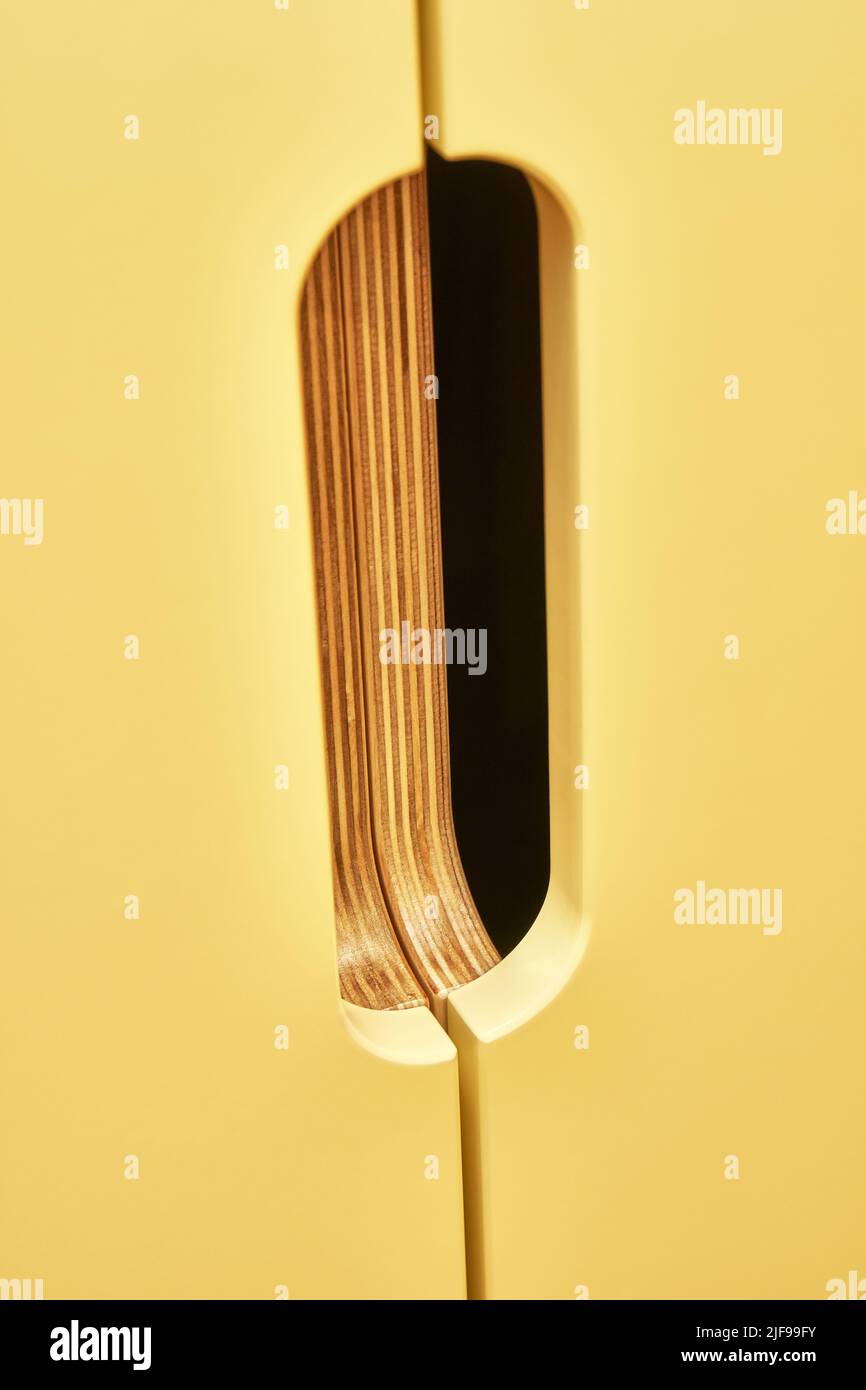 Fragment of children wardrobe made of plywood with yellow doors and