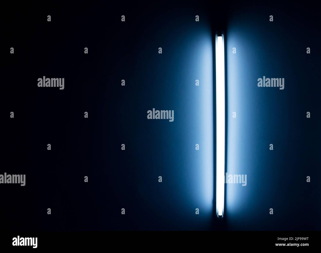 Detail of a fluorescent tube mounted on a wall, false green color light