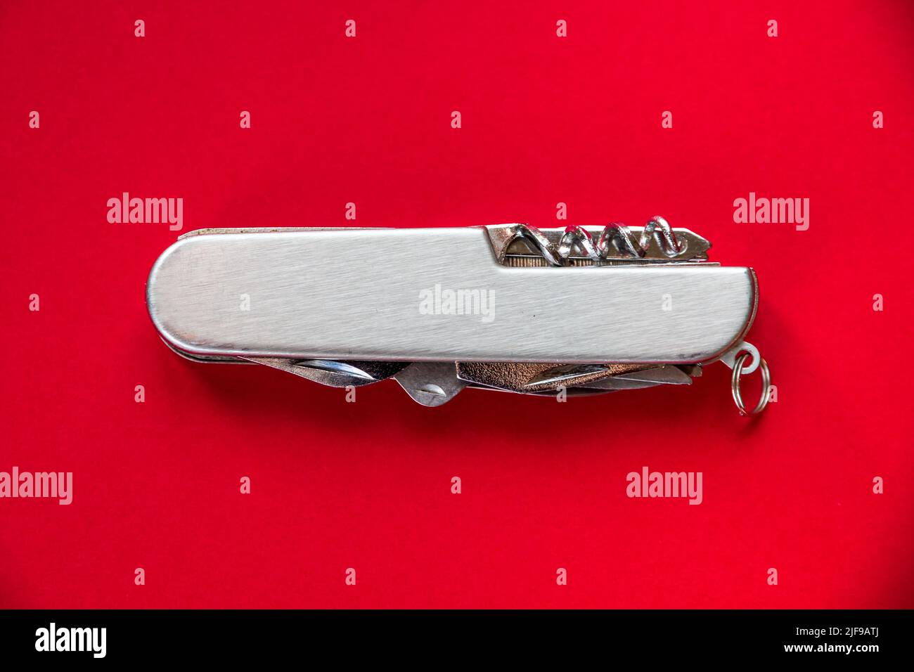 Metallic swiss knife isolated on red background Stock Photo