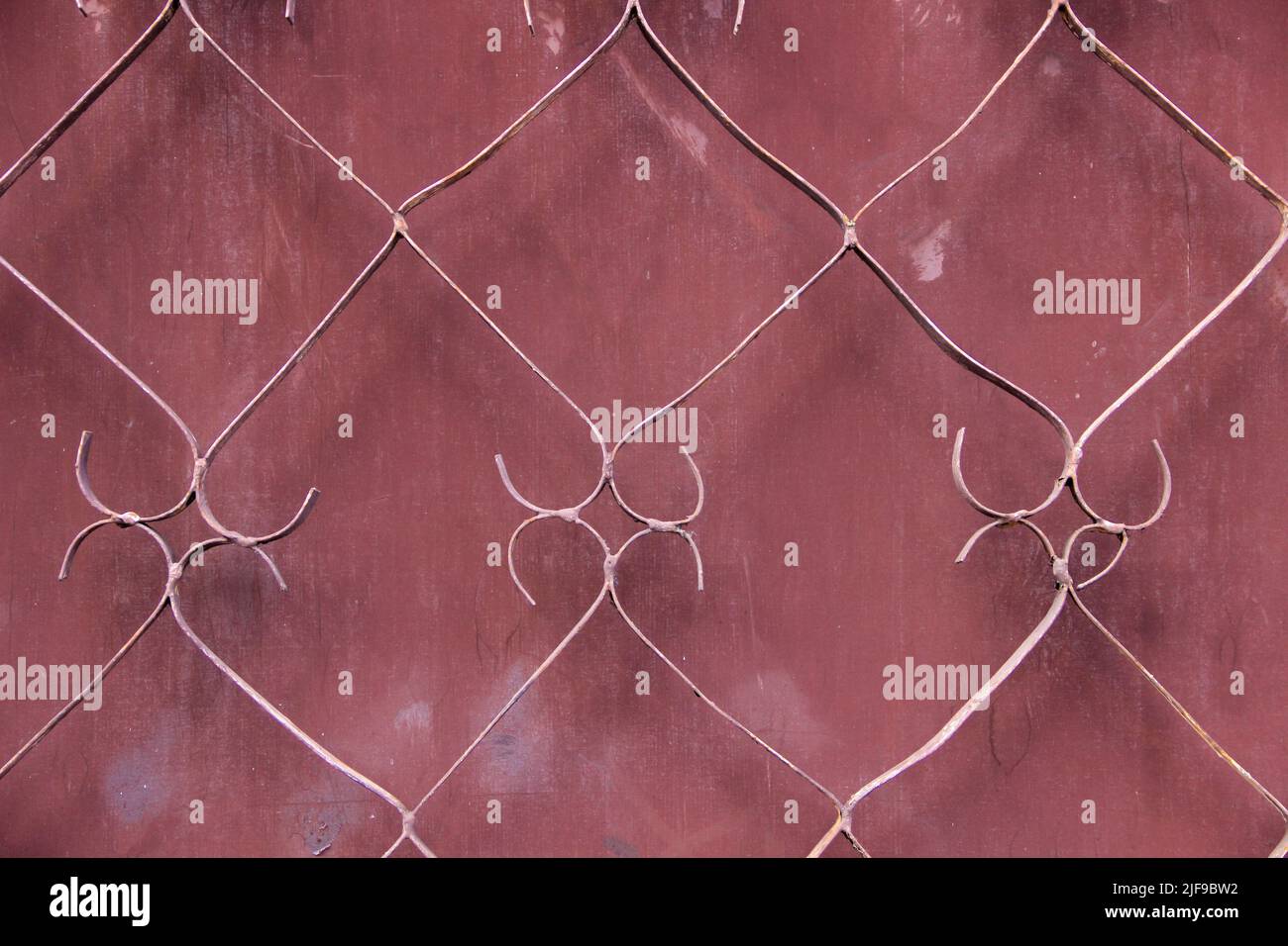 Wrought iron bar background. Maroon color weathered background Stock