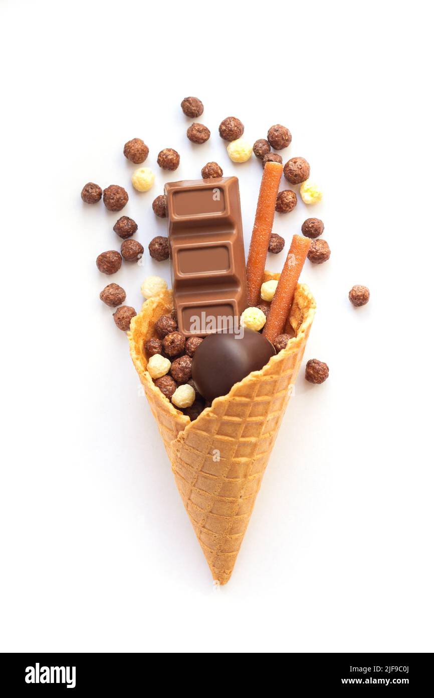 Ice cream waffle cone with different chocolate candy isolated on white ...