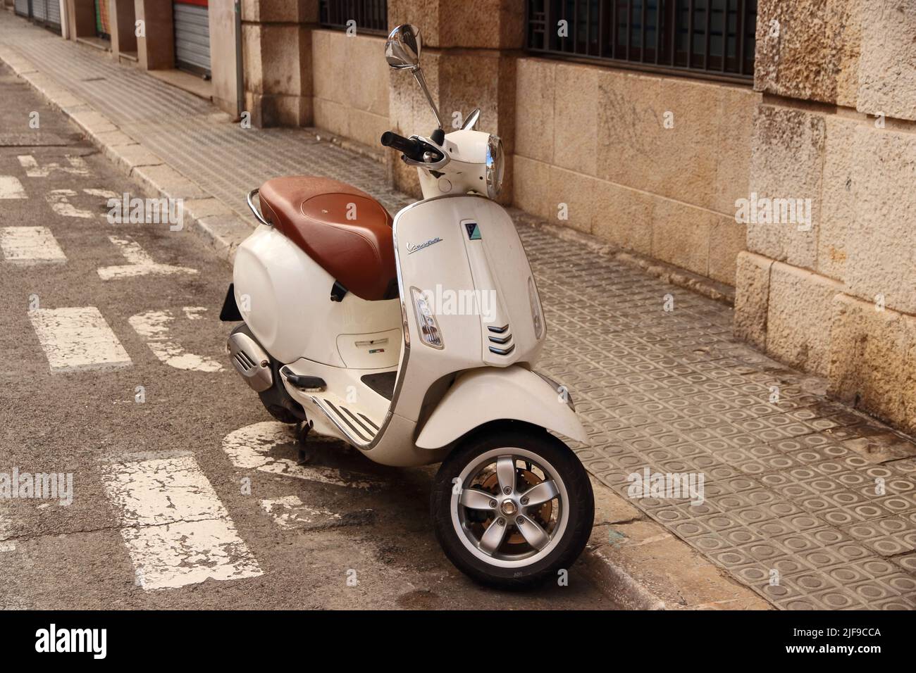 Cream coloured Vespa 125 3V ie scooter parked at roadside Stock Photo