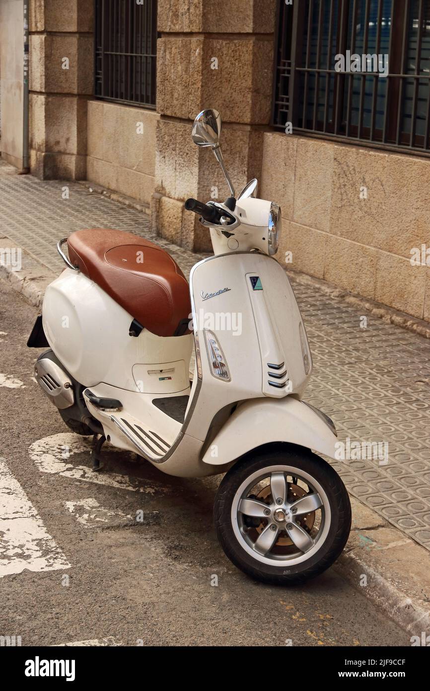 Cream coloured Vespa 125 3V ie scooter parked at roadside Stock Photo