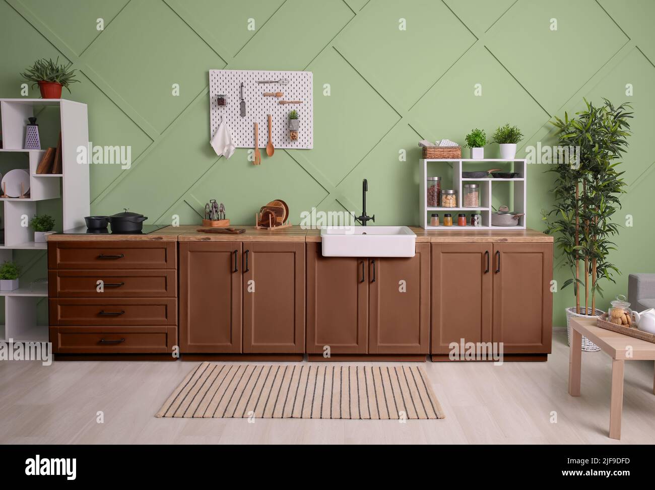 Interior of stylish kitchen with brown furniture, pegboard and shelving ...