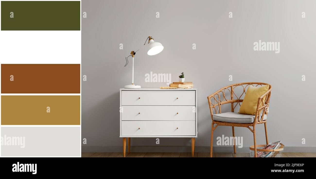 Chest of drawers and wicker chair near light wall. Different color ...