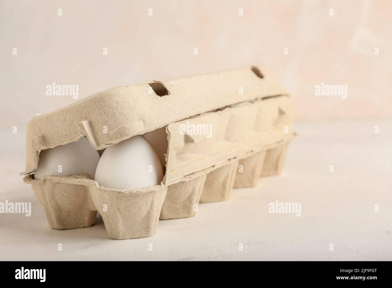 Cardboard holder with chicken eggs on light background Stock Photo - Alamy