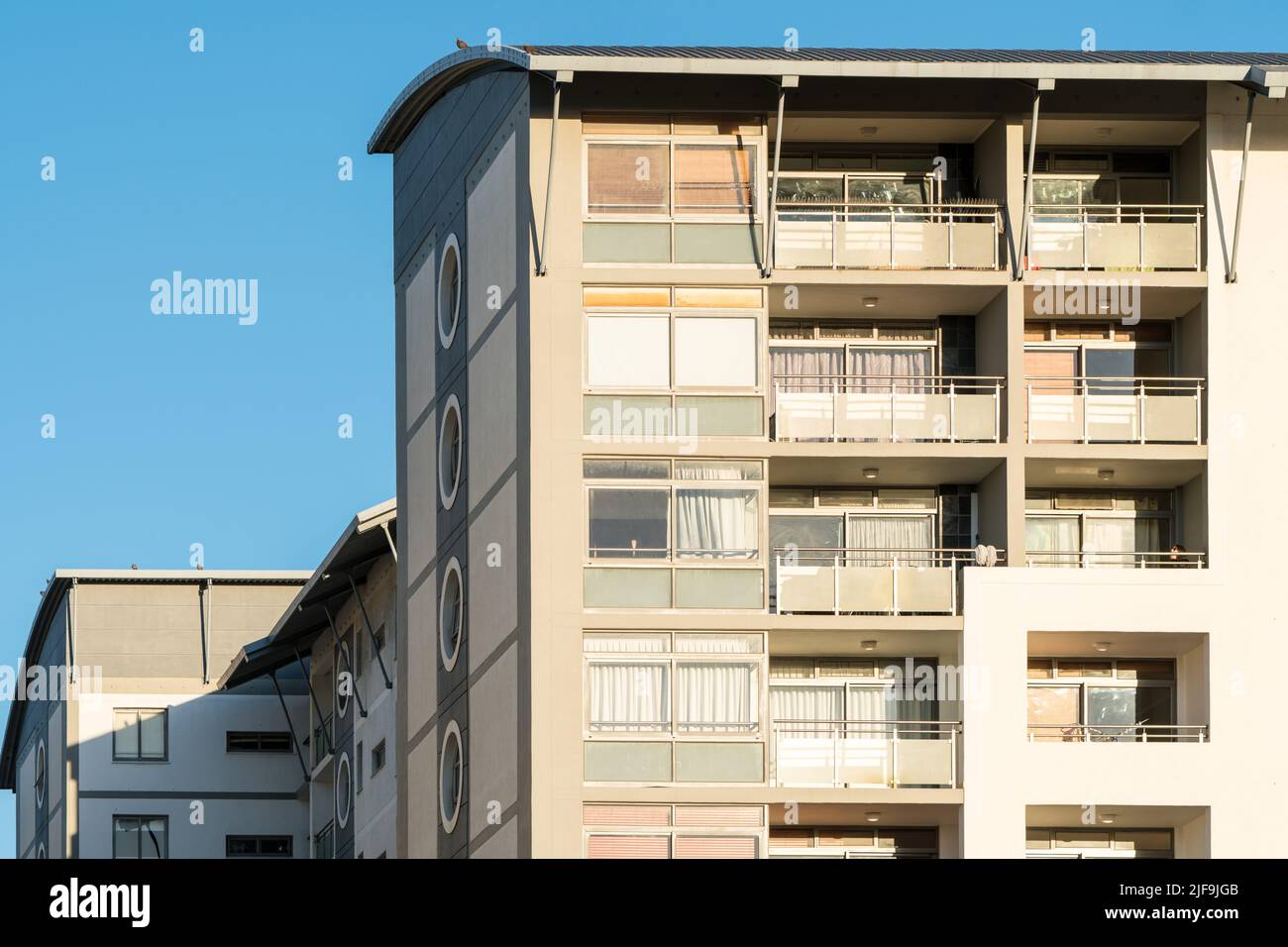 closeup of a section of apartment block or apartments showing the exterior facade with balconies in a modern or contemporary architectural design Stock Photo