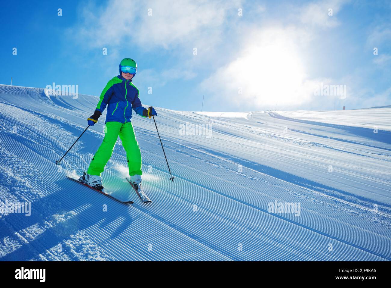 Preteen child ski downhill fast on fresh track at sunny morning Stock Photo
