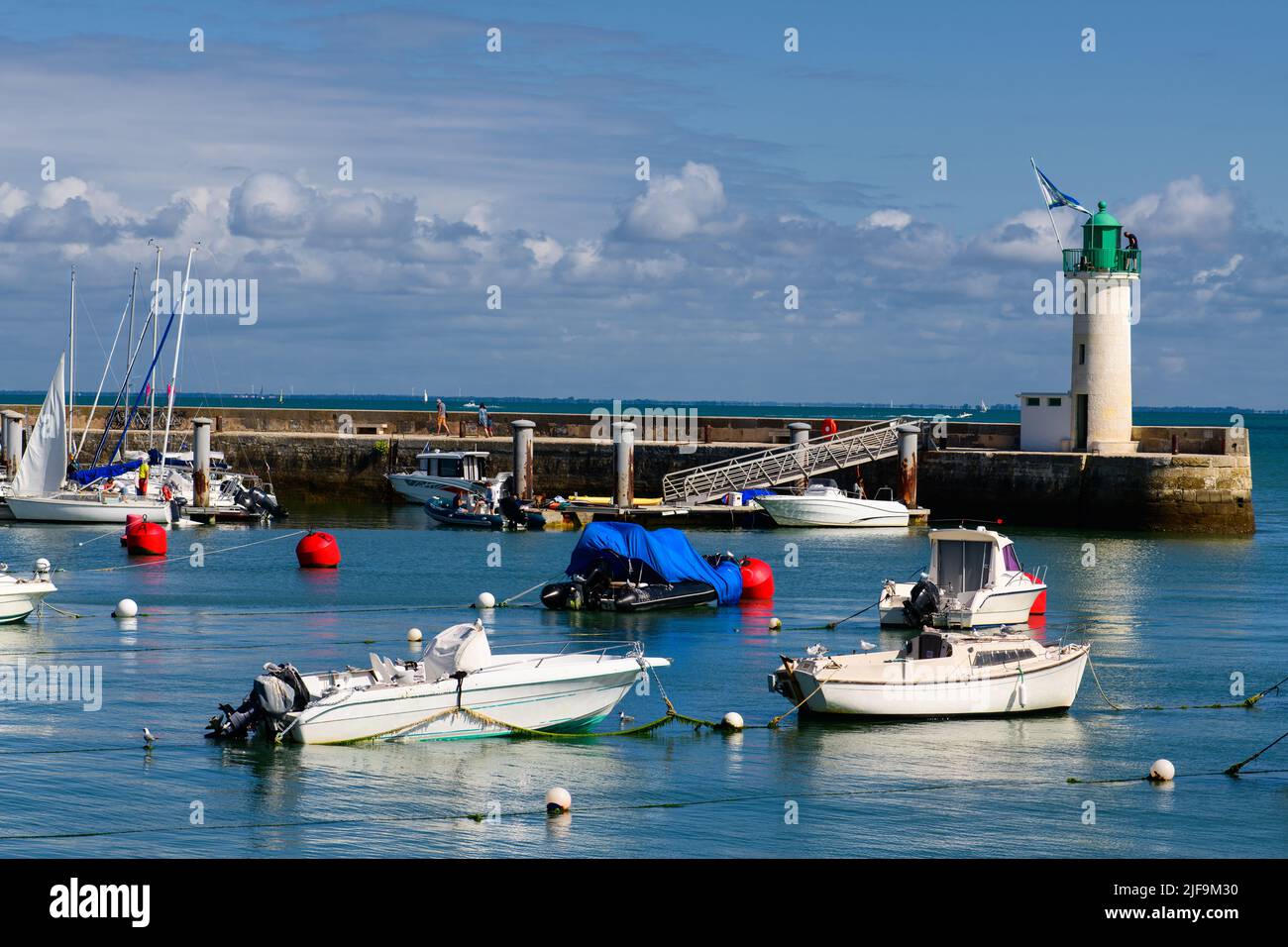 View on the Phare de la Flotte and some boats on the sea from the beach plage de l' Arnérault on a sunny summerday Stock Photo
