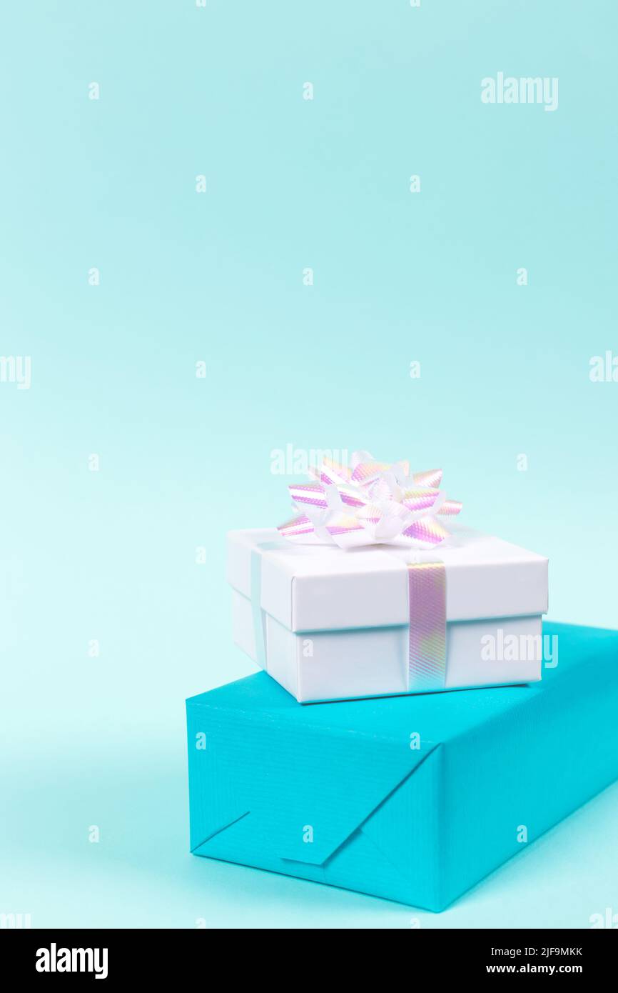 Vertical festive background made of two gift boxes on blue backdrop. Pastel colors. Holiday concept. Copy space Stock Photo