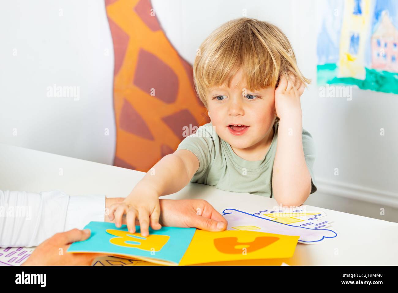 Little boy point to letters on the page in a book Stock Photo