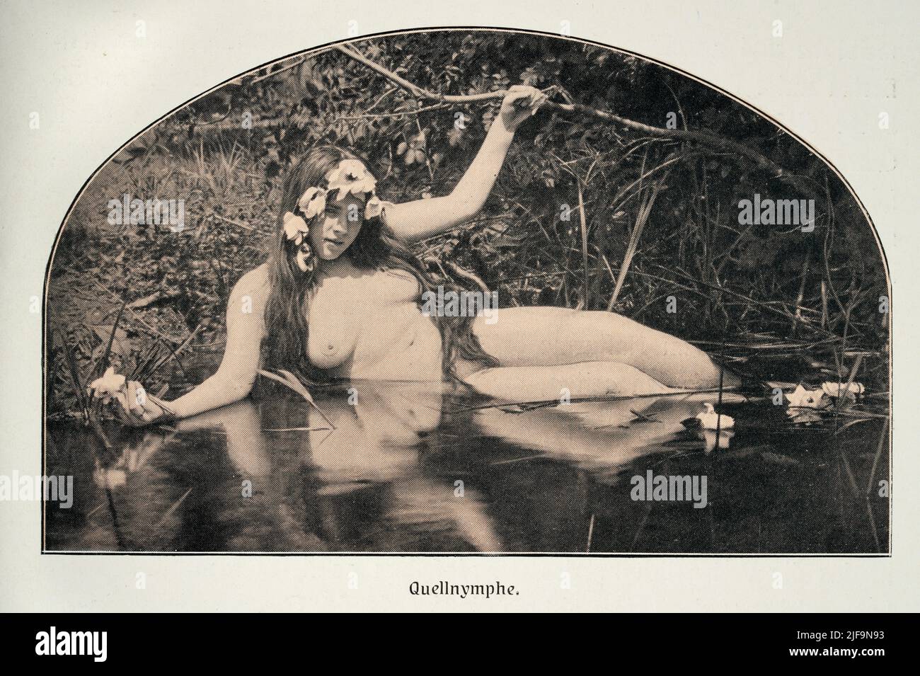 Early vintage photograph of a nude woman, Naiad or Water nymph, German, 1900s. Study of female beauty. Quellnymphe Stock Photo