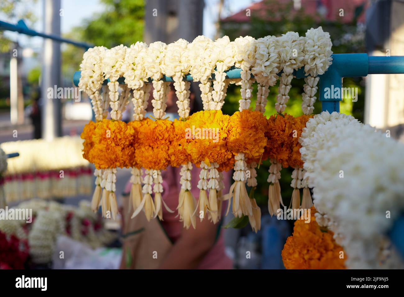 Fresh Jasmine mixed with marigold and crown flower garland hanging for sale at retail Stock Photo