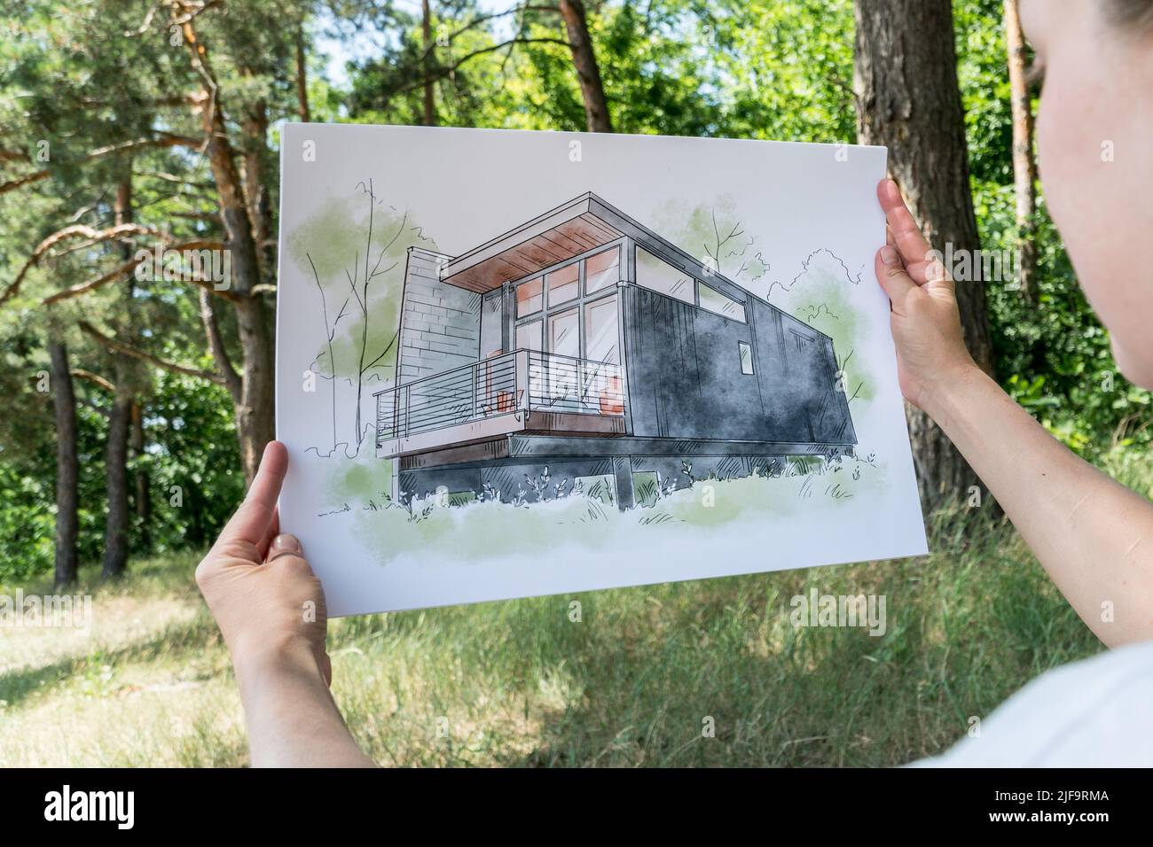 Contemporay house design hand drawn  sketch in architecht's hands.  Architectural design concept Stock Photo