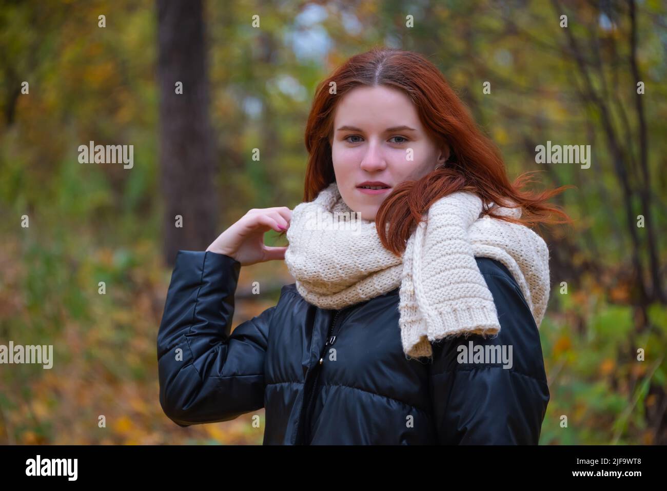 portrait of a red - haired smiling girl in a jacket smiling . against ...
