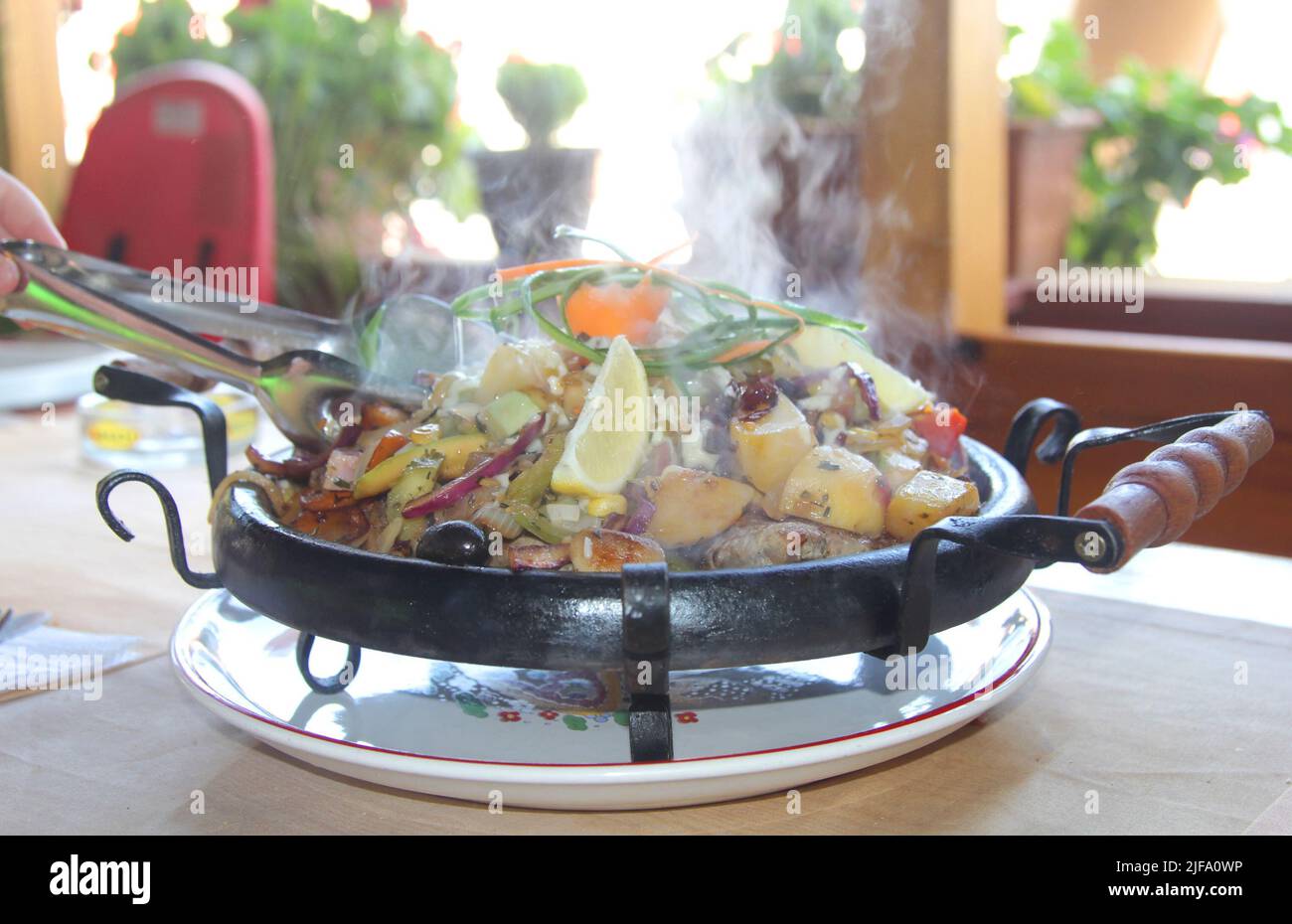 Sach - a large frying pan traditional for Bulgaria, in which dishes are prepared for several people, and served on the table in it. Nessebar, Bulgaria Stock Photo