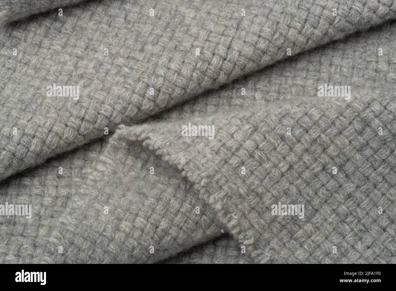 Textured fabric background. A grey woollen blanket material in folds. Stock Photo