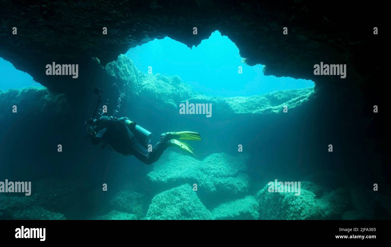 Scuba diver photographer swim in the cave. Cave diving in Mediterranean ...