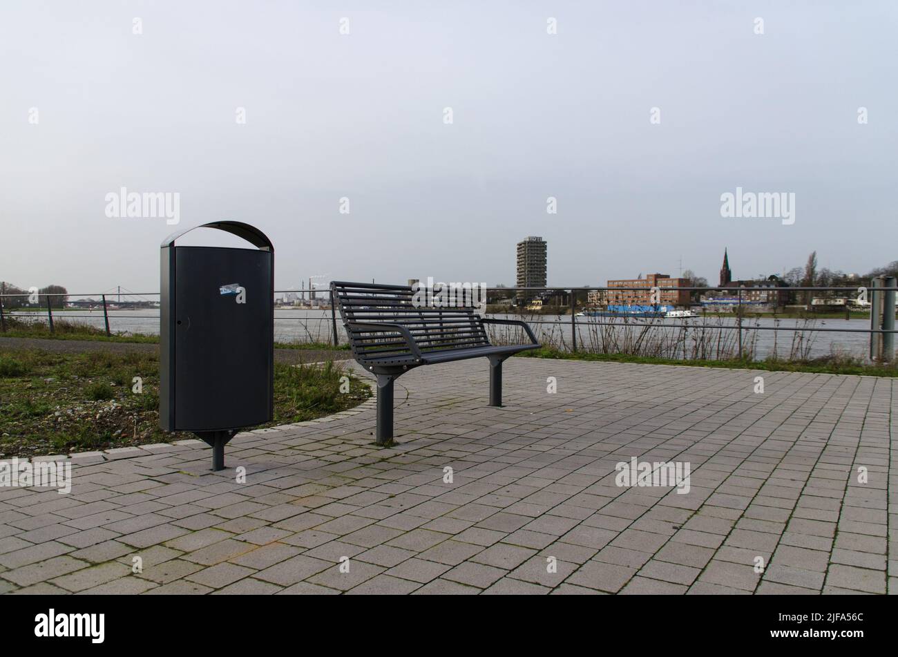 Garbage can / rubbish bin next to a bench at the river bank in Duisburg