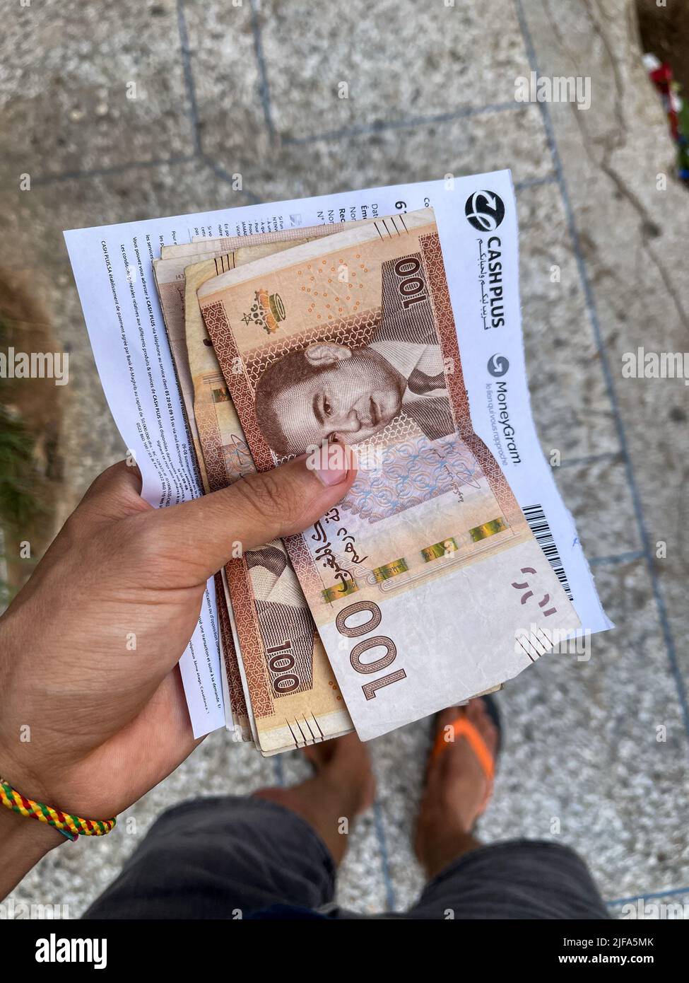 Hand holding 100DH bank notes in Morocco Stock Photo