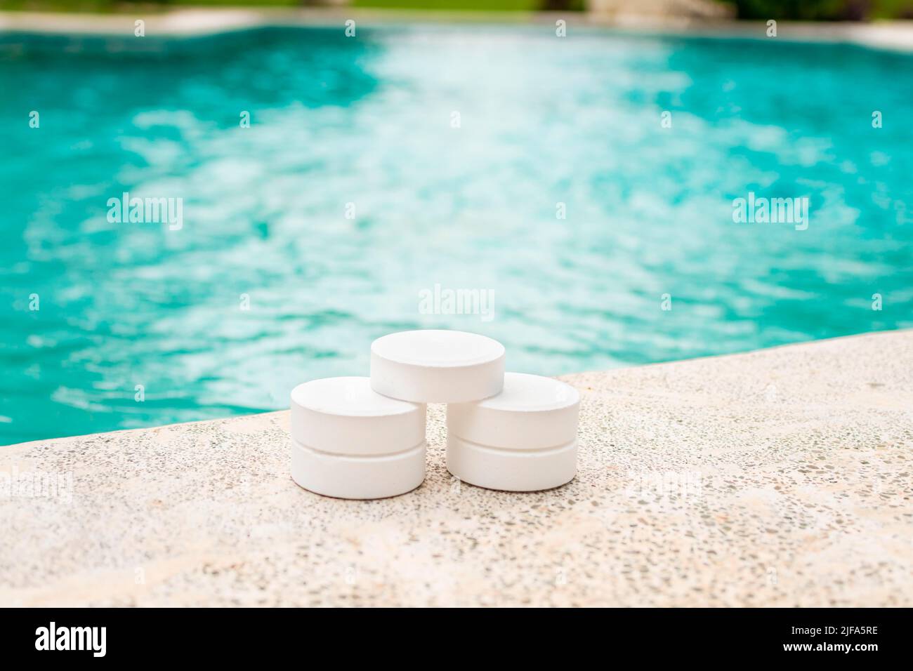 Chlorine tablets on the edge of a swimming pool, Closeup of chlorine tablets for swimming pool cleaning, chlorine tablets for swimming pool Stock Photo