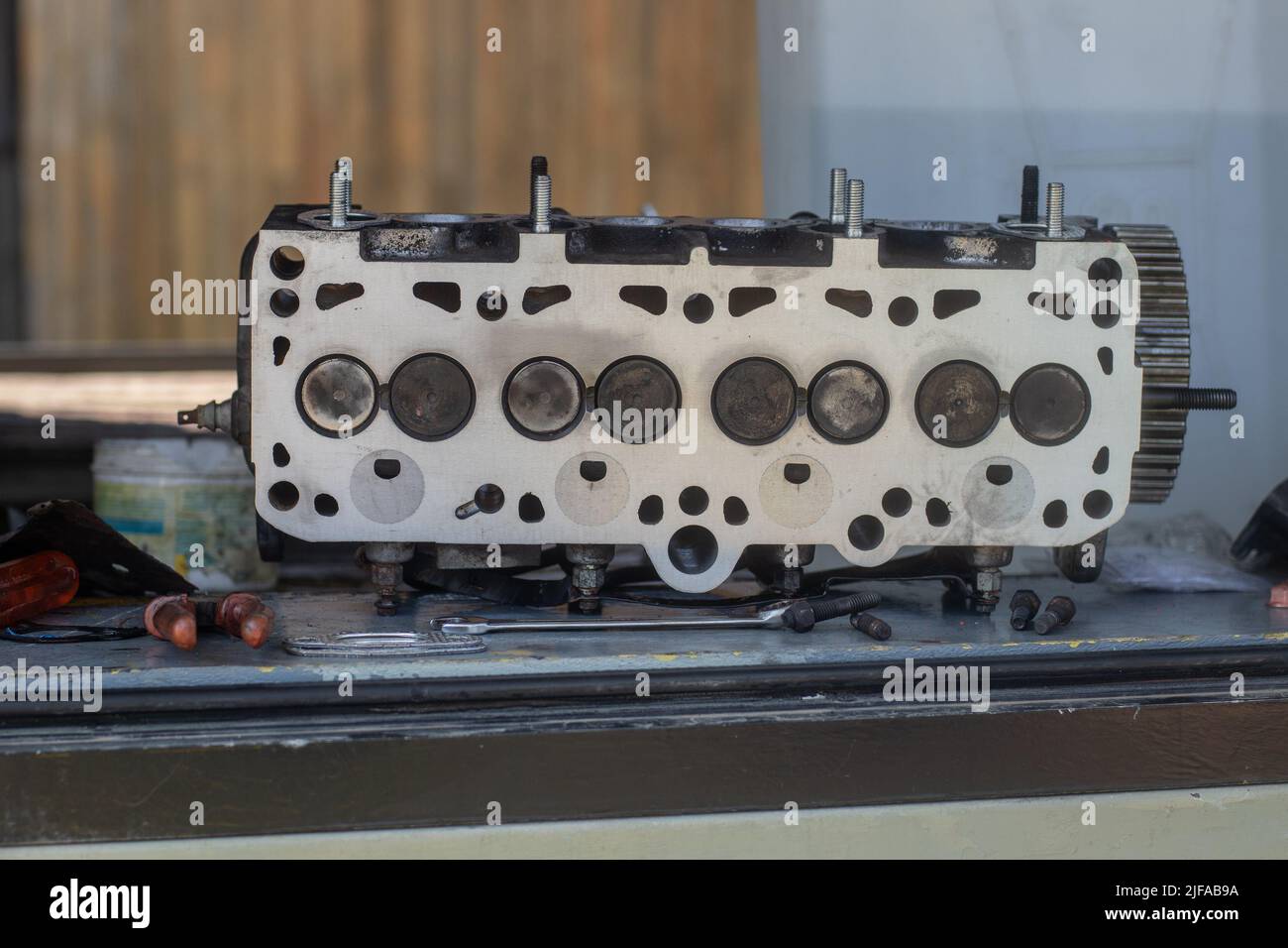 Old cylinder head of a 8V diesel engine sitting on a bench or atable