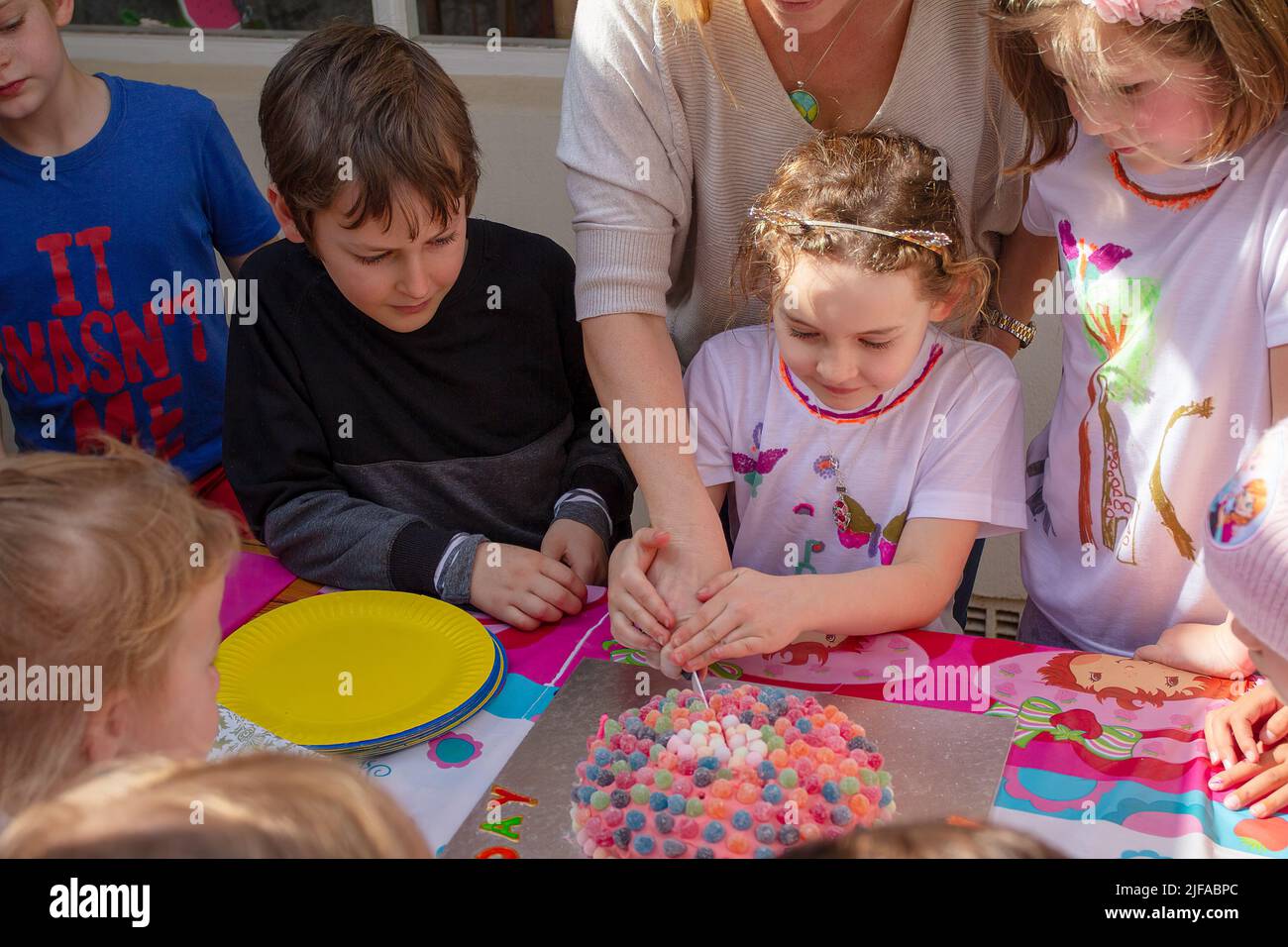 Cutting the cake at a kids birthday party Stock Photo