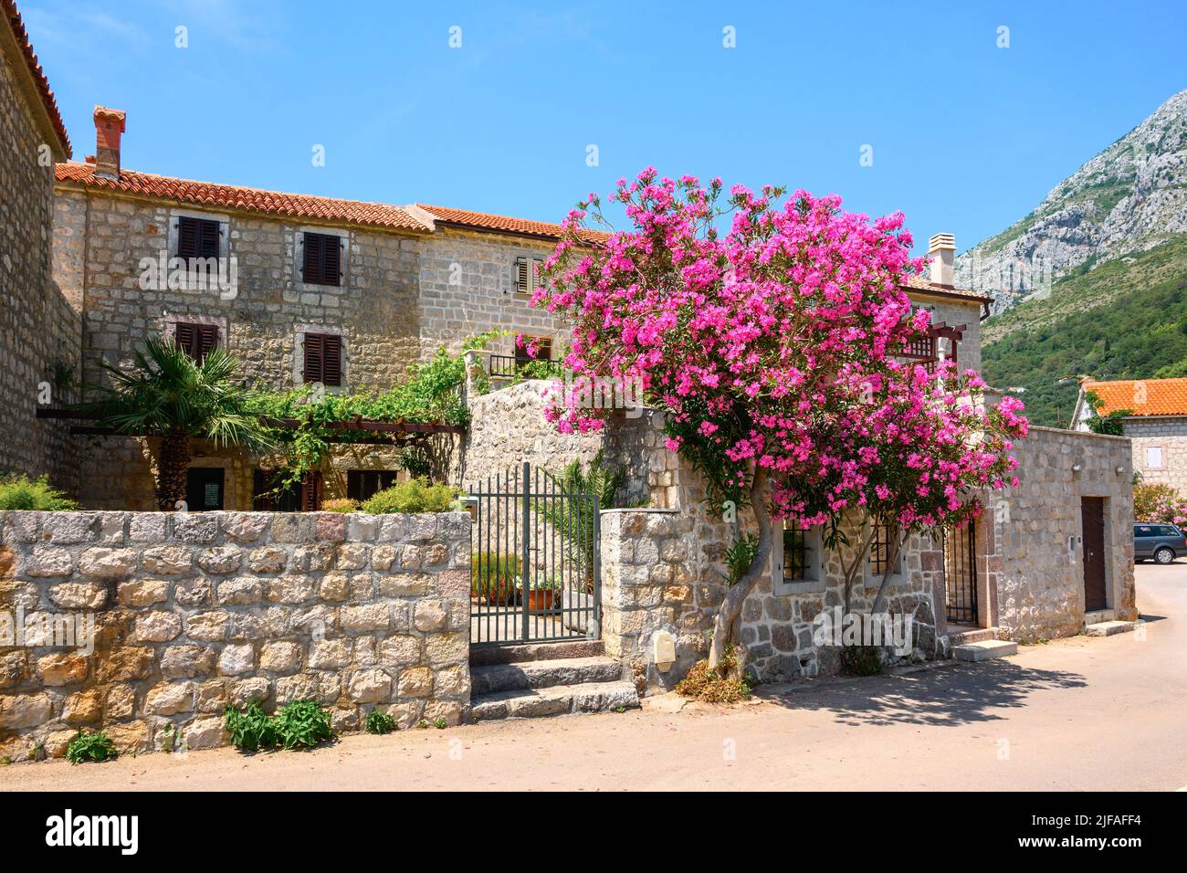 Traditional stone house decorated with flowers in Rijeka Rezevici