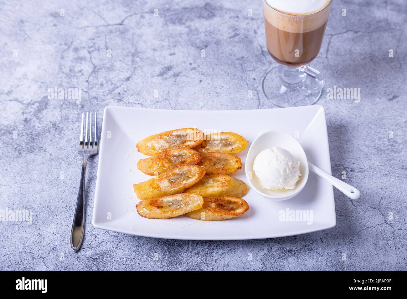Fried bananas with honey, cinnamon, coffee and ice cream. Closeup