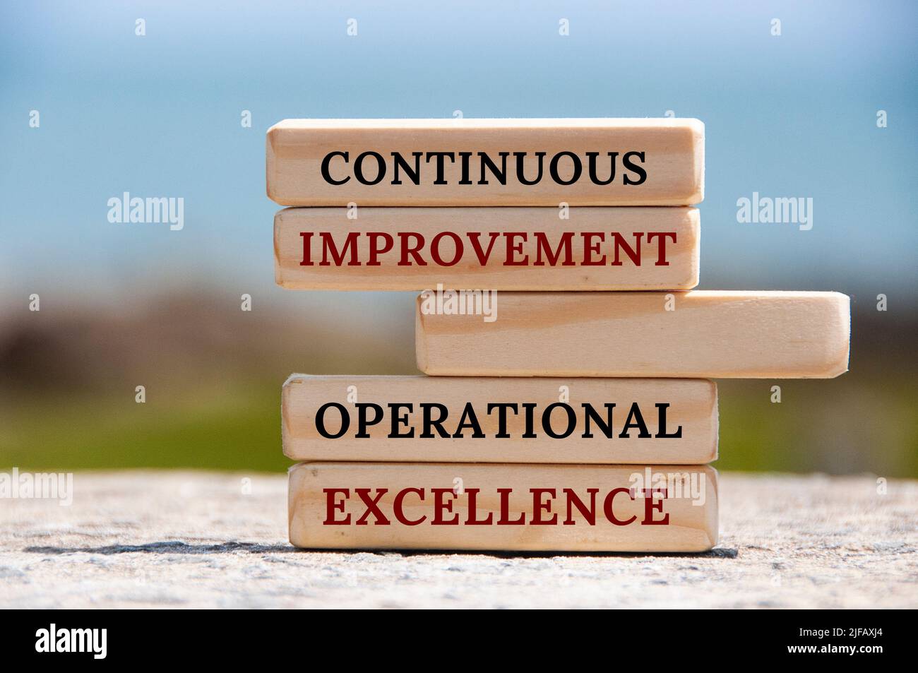 Continuous improvement Operational excellence text on wooden blocks with blurred nature background. Business concept Stock Photo