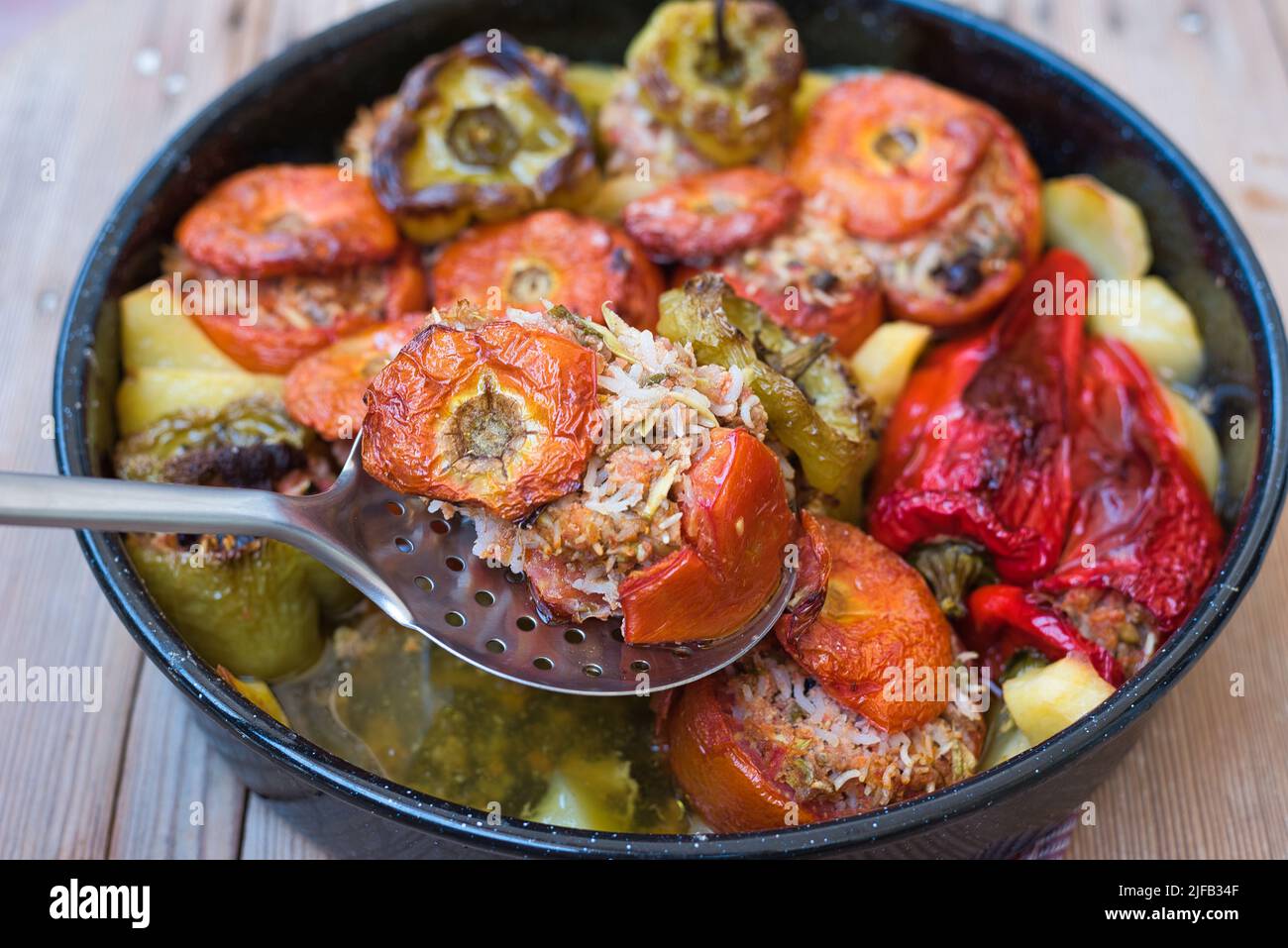 Greek summer food, gemista. stuffed tomatoes and peppers with rice, onion, minced meat, cooked in the oven. tasty and light food. Stock Photo