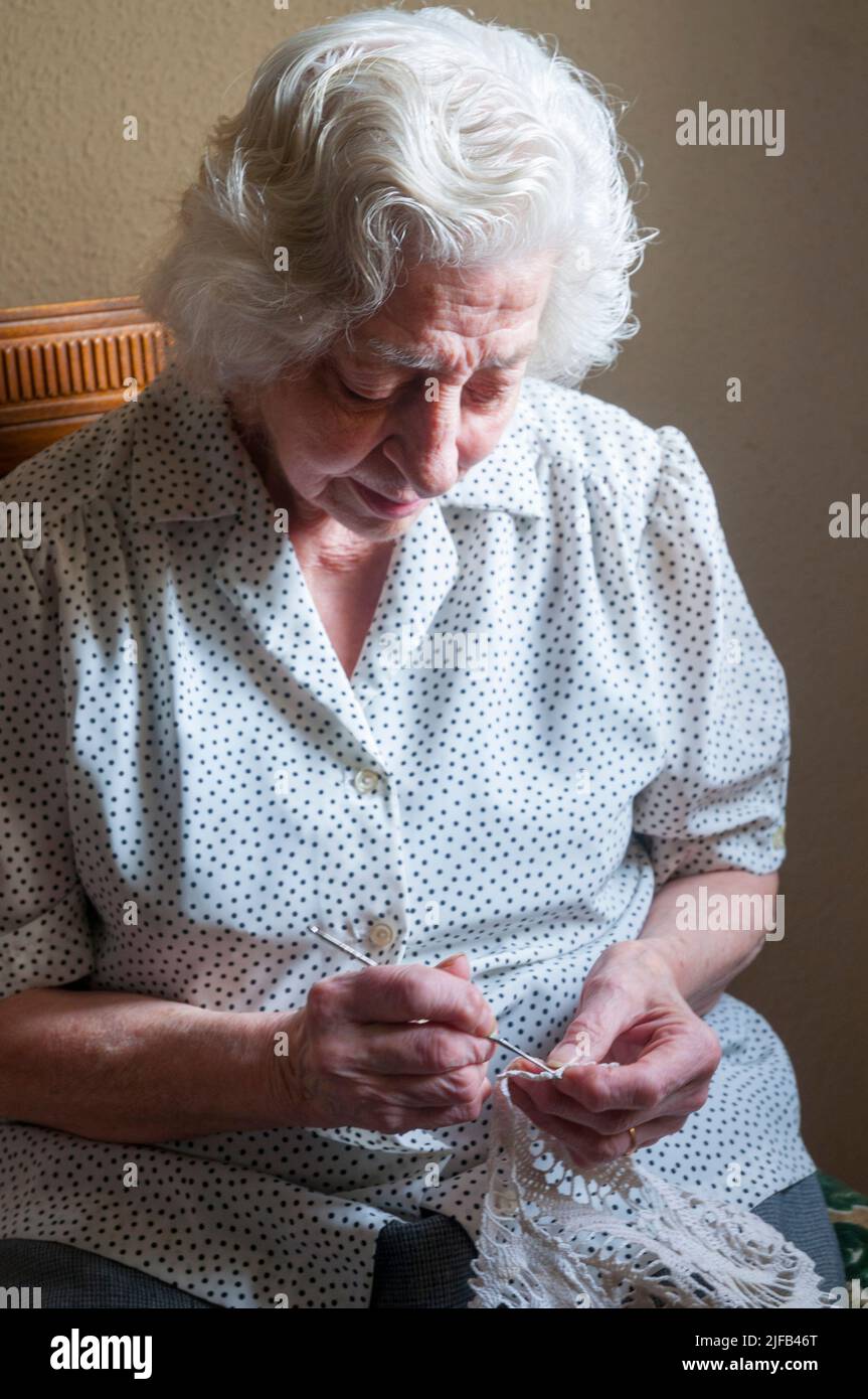 Old lady crochetting. Stock Photo