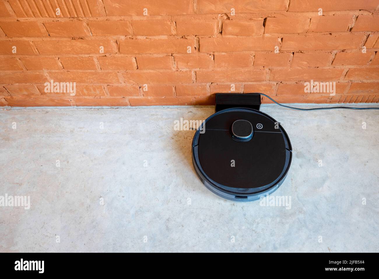 Robotic vacuum cleaner charging on dock station Stock Photo Alamy