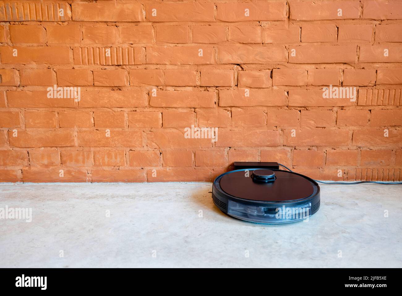 Robotic vacuum cleaner charging on dock station Stock Photo Alamy