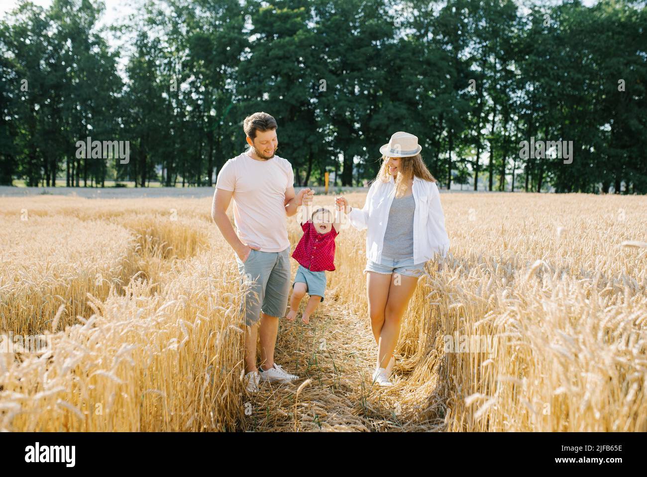 Happy family walking in wheat field Stock Photo - Alamy