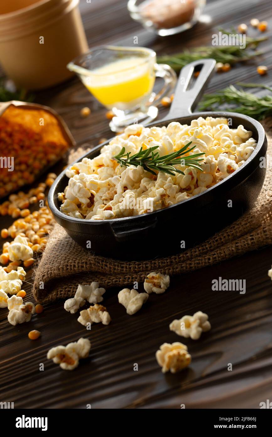 Popcorn in cast iron skillet with paper bucket and melted butter aside
