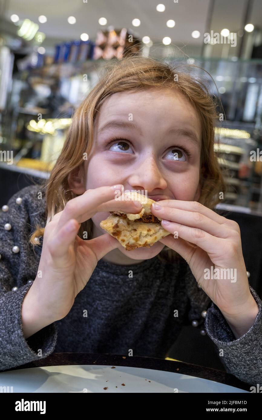 France, Paris, Maison Béchu, young girl tasting pastries, mille-feuille Stock Photo