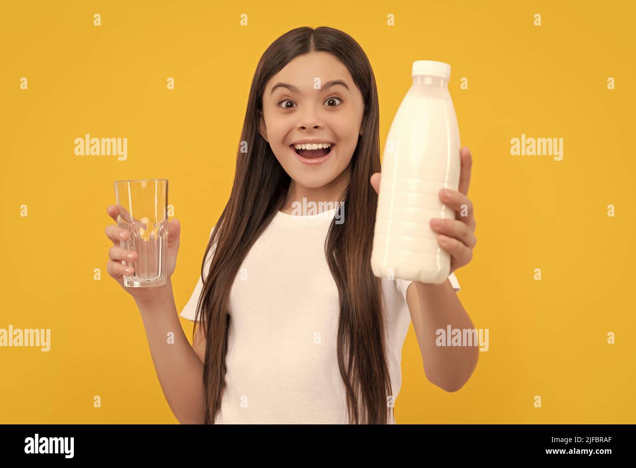 amazed child offer dairy beverage product. teen girl going to drink milk. Stock Photo