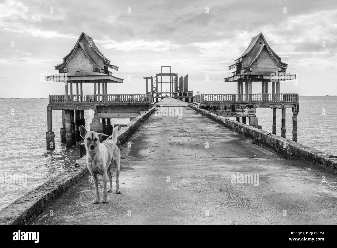 Thai monks at a pier leading to an unfinished temple in Thailand Southeast Asia Stock Photo